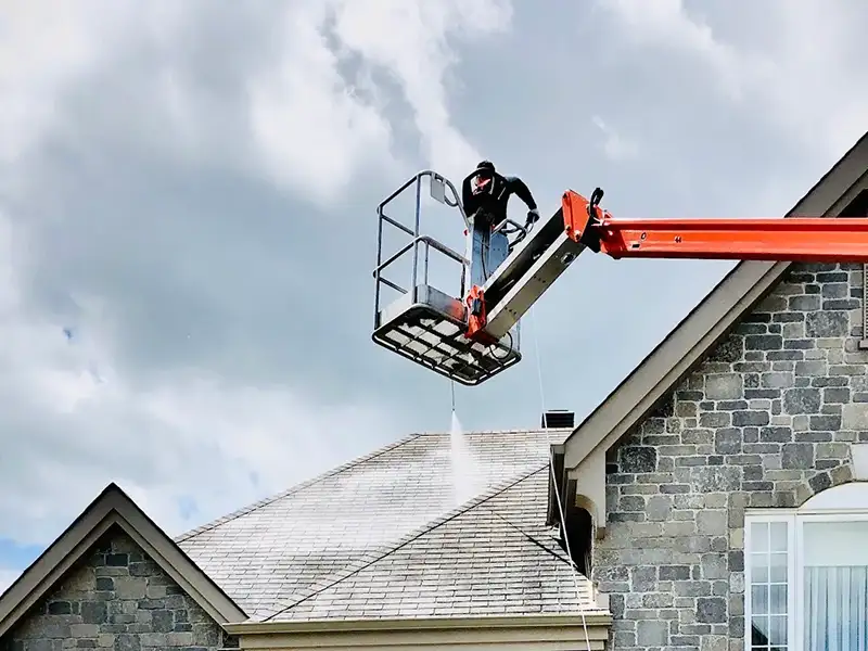 Worker spraying GoNano formula on roof